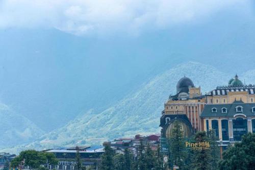 a large building in front of a mountain at Sapa Pine Hill Eco Lodge in Sa Pa