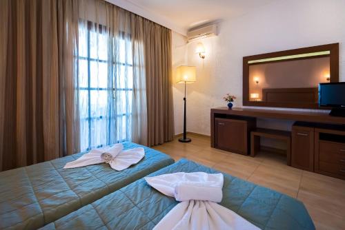 a hotel room with two beds and a mirror at Gaia Garden in Kos Town