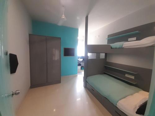 a bedroom with two bunk beds with blue walls at FF21-Hbr in Bengaluru