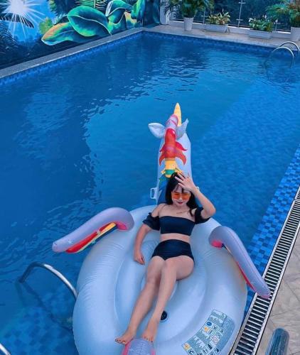 a woman is laying on an inner tube in a swimming pool at Sapa Passion Hotel & Spa in Sa Pa