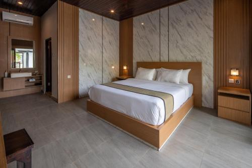 a bedroom with a large bed and a bathroom at Abasan Hill Hotel and Spa in Nusa Penida