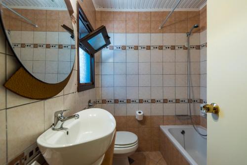 a bathroom with a sink and a toilet and a mirror at Gaia Garden in Kos Town