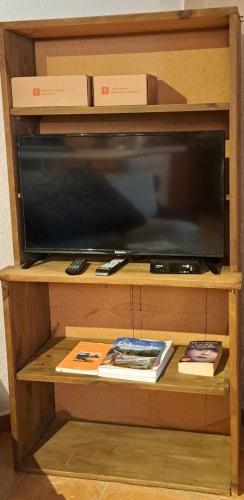- une télévision sur une étagère en bois dans l'établissement Le bastidon le pavillon, à Fox-Amphoux