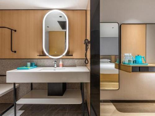 - deux photos d'une salle de bains avec lavabo et miroir dans l'établissement City Comfort Inn Wuhan Pangxiejia Metro Station, à Wuhan