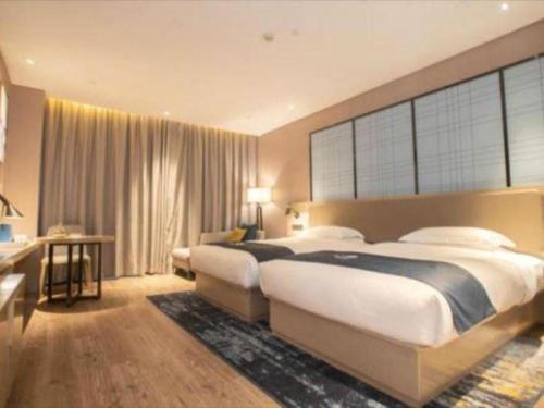 a large bedroom with two beds and a desk at Echarm Hotel Changde Taoyuan Walking Street Jinyuan Tower in Changde