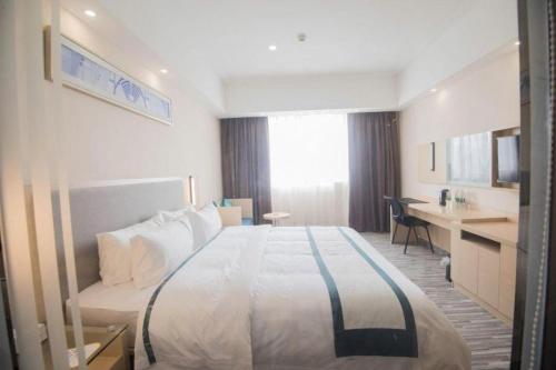 a hotel room with a large bed and a desk at City Comfort Inn Shantou Daxue Road in Shantou