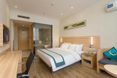 a hotel room with a large bed and a desk at City Comfort Inn Wuhan Zoo Guobo Maying Road Metro Station in Wuhan