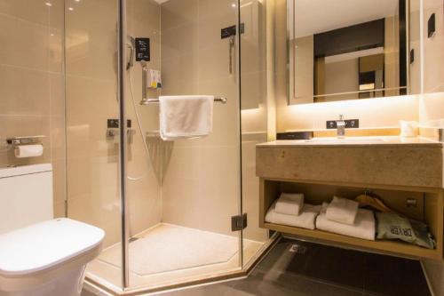 a bathroom with a shower and a toilet and a sink at City Comfort Inn Nanning Taoyuan Road in Nanning