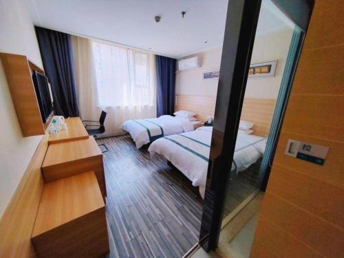 a hotel room with two beds and a mirror at City Comfort Inn Wuhan Dream Times Meiyuan Community Metro Station in Wuhan