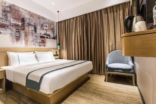 a hotel room with a bed and a chair at City Comfort Inn Nanning Taoyuan Road in Nanning