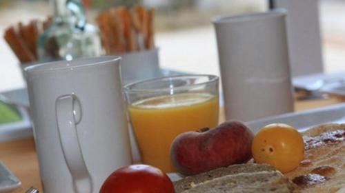 een ontbijt bestaande uit geroosterd brood, sinaasappelsap en fruit bij Hotel Cortijo Las Piletas in Ronda