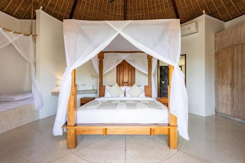 un dormitorio con una cama con dosel en Island Bungalow in Perfect Location Bingin Bali, en Uluwatu