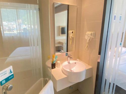 a bathroom with a sink and a shower with a mirror at City Comfort Inn Tongren High-speed Railway Station in Tongren