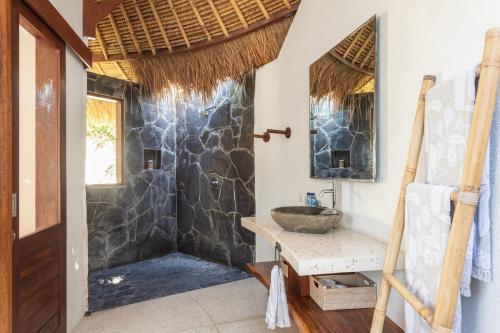 y baño con ducha de piedra con lavabo. en Island Bungalow in Perfect Location Bingin Bali, en Uluwatu