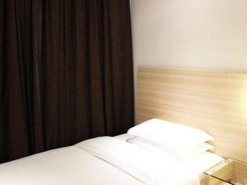 a bedroom with a bed with a black curtain at City Comfort Inn Wuhan Zhongnan Road Metro Exit in Wuhan