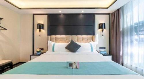 a bedroom with a large bed with a large headboard at Xana Hotelle Nanchang Tengwang Pavilion Wanshougong in Nanchang
