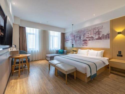 Un pat sau paturi într-o cameră la City Comfort Inn Jinan Railway Station Daming Lake