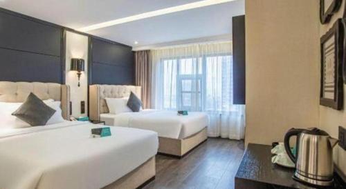a hotel room with two beds and a window at Xana Hotelle Nanchang Tengwang Pavilion Wanshougong in Nanchang
