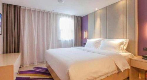 a bedroom with a large white bed and a window at Lavande Hotels Wuhan Guanggu Yangjiawan Metro Station in Wuhan