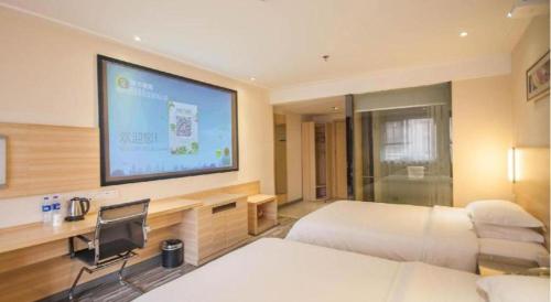 a hotel room with two beds and a flat screen tv at City Comfort Inn Yichang Dongshan Three Gorges University Shuiyuecheng in Yichang