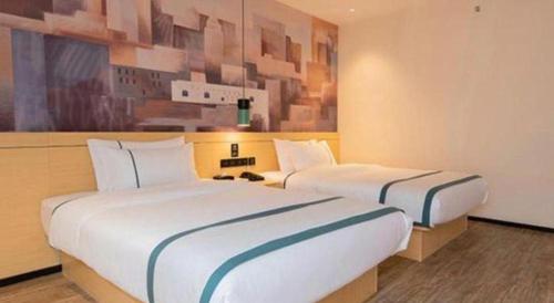 two beds in a hotel room with two beds sidx sidx sidx at City Comfort Inn Kunming High Speed Railway South Station Yongxin Harvard in Kunming