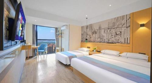 a hotel room with two beds and a flat screen tv at City Comfort Inn Kunming High Speed Railway South Station Yongxin Harvard in Kunming