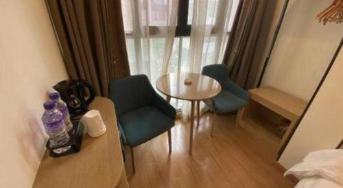 a room with two chairs and a table and a window at City Comfort Inn Kunming High Speed Railway South Station Yongxin Harvard in Kunming