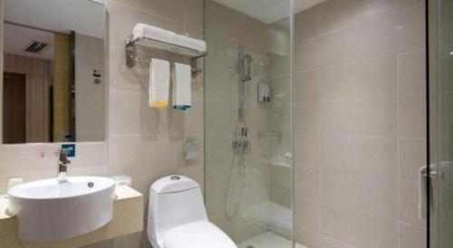 a bathroom with a shower and a toilet and a sink at City Comfort Inn Kunming High Speed Railway South Station Yongxin Harvard in Kunming