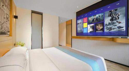 a bedroom with a large screen on the wall at City Comfort Inn Kunming High Speed Railway South Station Yongxin Harvard in Kunming