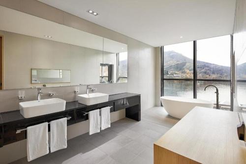 a bathroom with two sinks and a tub and a large mirror at Hotel Haus in Gapyeong