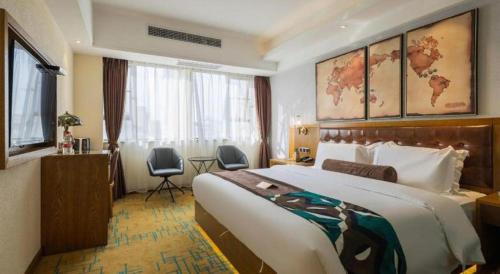 a hotel room with a large bed and a desk at James Joyce Coffetel Kunming Railway Station Huancheng Nan Road Metro Station in Kunming