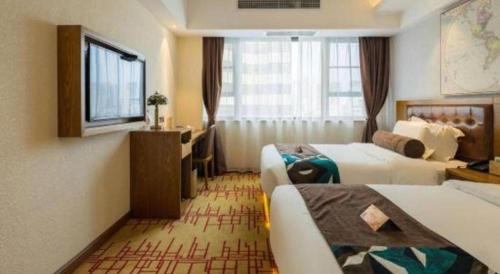 a hotel room with two beds and a desk at James Joyce Coffetel Kunming Railway Station Huancheng Nan Road Metro Station in Kunming