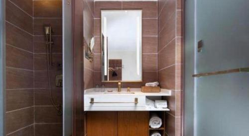 a bathroom with a sink and a mirror at James Joyce Coffetel Luoyang Longmen High-speed Railway Station Baolong Plaza in Luoyang
