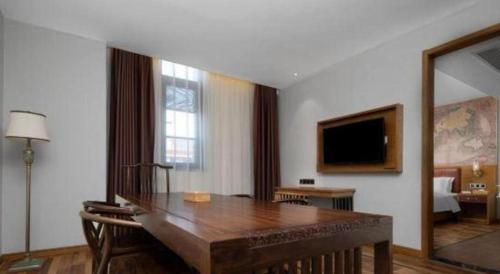 a living room with a table and a mirror at James Joyce Coffetel Luoyang Longmen High-speed Railway Station Baolong Plaza in Luoyang