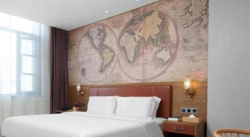 a bedroom with a large bed with a map on the wall at James Joyce Coffetel Luoyang Longmen High-speed Railway Station Baolong Plaza in Luoyang