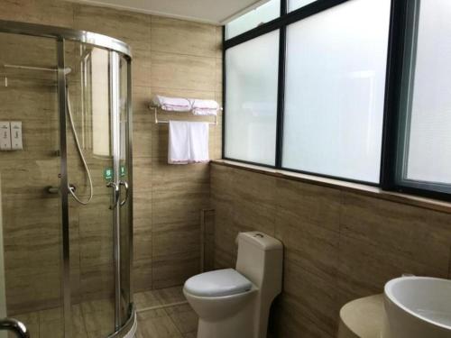 a bathroom with a shower and a toilet and a sink at Shell Hotel Shanghai Minhang District Wenjing Road Metro Station in Shanghai
