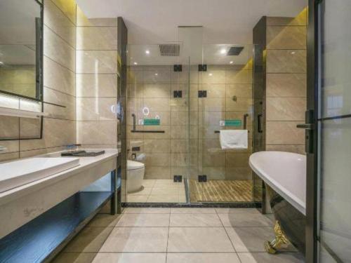 a bathroom with a tub and a toilet and a shower at Xana Lite Hotelle Yan'an Baota Mountain in Yan'an