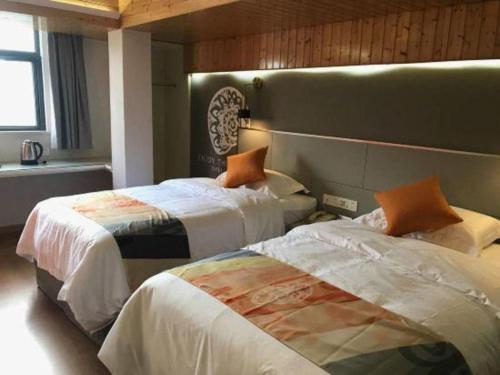 a hotel room with two beds in a room at Shell Hotel Shanghai Minhang District Wenjing Road Metro Station in Shanghai