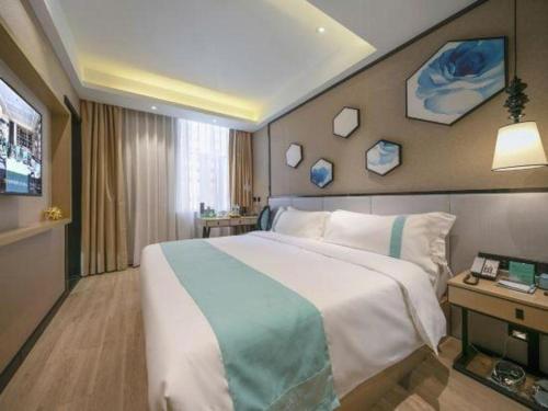 a hotel room with a large bed and a television at Xana Lite Hotelle Yan'an Baota Mountain in Yan'an