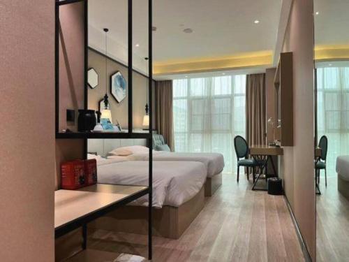 a hotel room with two beds and a desk in it at Xana Lite Hotelle Yan'an Baota Mountain in Yan'an