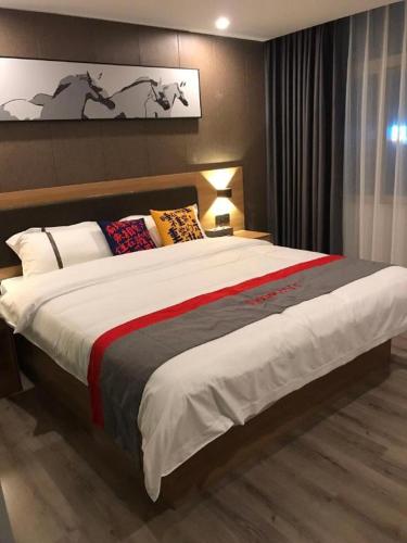 a bedroom with a large bed in a room at Jun Hotel Guangdong Zhanjiang Xiashan South Railway Station in Zhanjiang