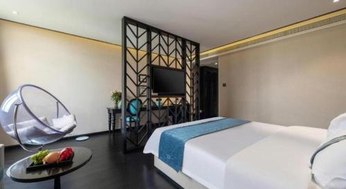 a bedroom with a bed and a table with fruit on it at Xana Hotelle Wuxi Railway Station Zhongshan Road in Wuxi