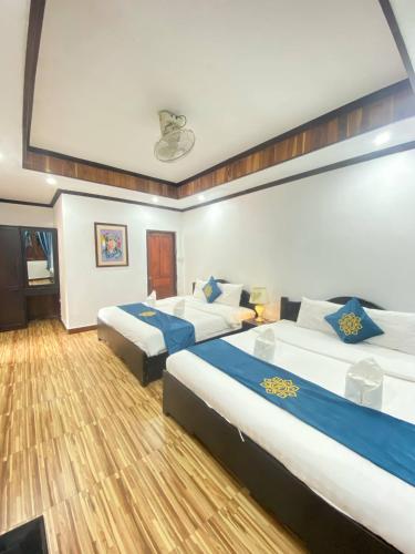Postel nebo postele na pokoji v ubytování Luangprabang Singharat Place 2