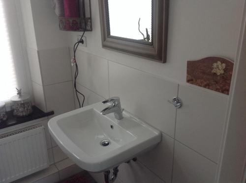 a white sink in a bathroom with a window at Zweitheimat in Kalkar