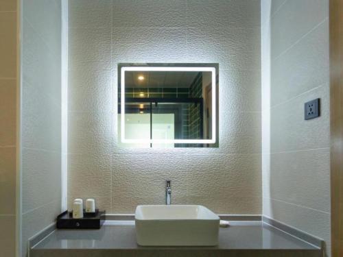 a bathroom with a sink and a mirror at GreenTree Inn Express Datong High-Speed Railway Station Wanda Plaza Fangte in Datong