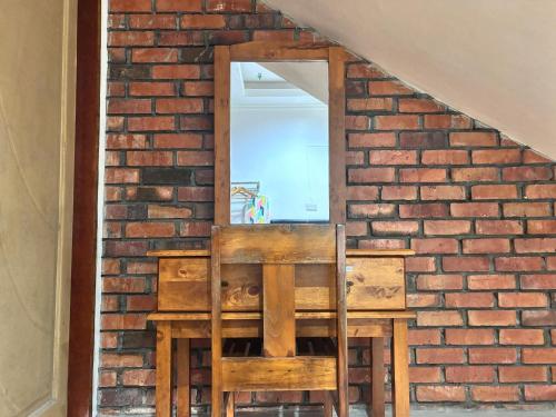a brick wall with a table and a mirror at Kundasang Guesthouse in Kundasang