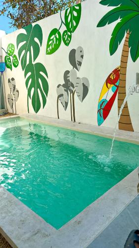 a swimming pool with a painting on the side of a wall at Casa Ha Hermosa Casa en Progreso Yucatan in Progreso