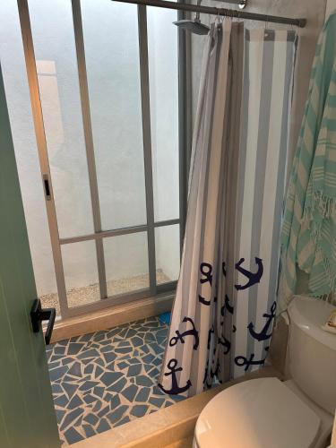 a bathroom with a shower curtain and a window at Casa Ha Hermosa Casa en Progreso Yucatan in Progreso