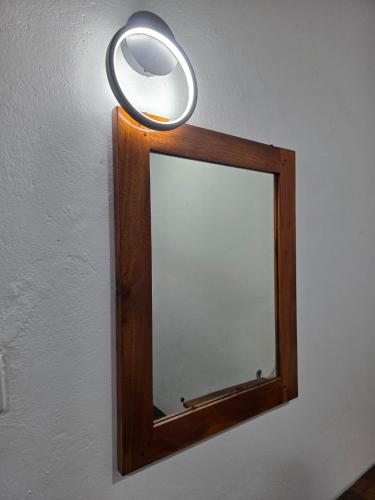 a mirror on a wall with a light above it at Coastal Heaven Villa in Trincomalee