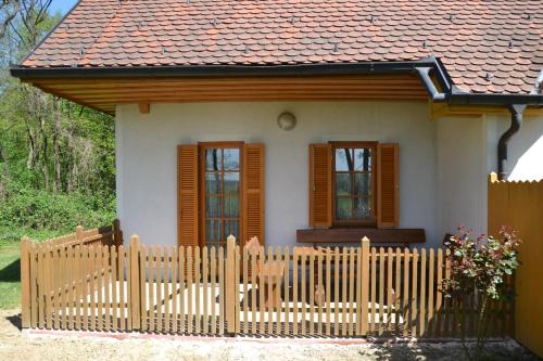 a small house with a wooden fence in front of it at Apartma Marjetica 47 in Moravske Toplice